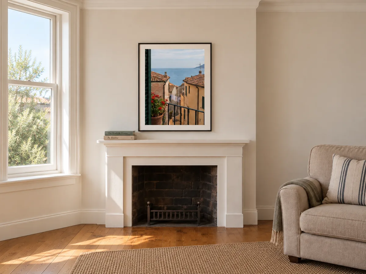 Coastal photograph in a black frame above a fireplace